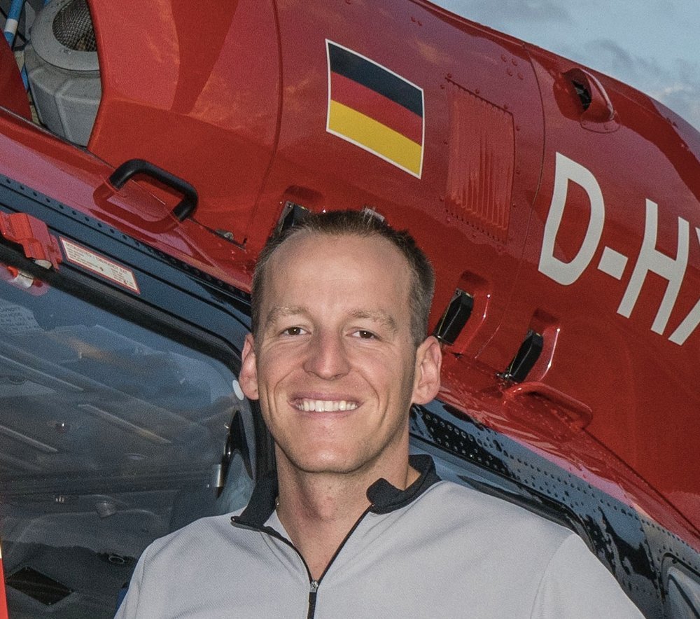 Lucas Sälzle, Notfallsanitäter, vor einem Rettungshubschrauber